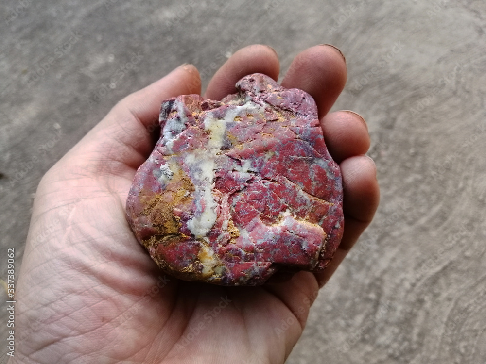 Jasper stone and quartz veins in the hand. red stone, Jasper stone is an  aggregate mineral commonly used in New Age practices and in feng shui.  Blood Jasper Stone. Stock Photo