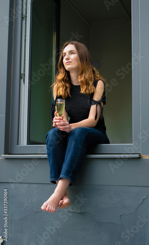 Beautiful and happy girl having a drink in the window