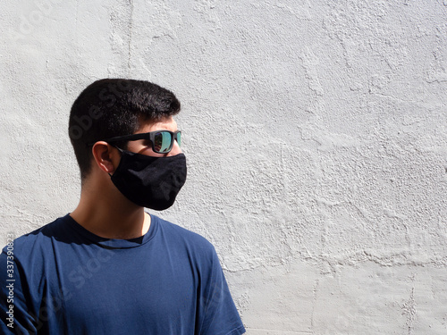 Young man with a black face mask and sunglasses