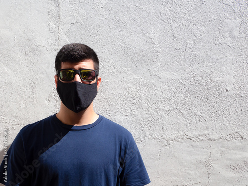 Young man with a black face mask and sunglasses