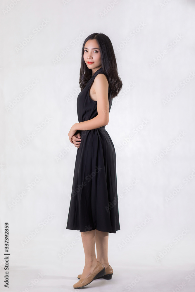 Beautiful Asian woman wear black dress. Standing in front of a white background. Beautiful Asian woman wear black dress. Standing in front of a white background.