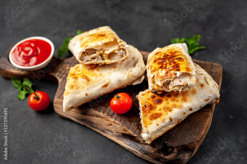 Burrito wraps with chicken and vegetables , against a background of concrete, Mexican shawarma