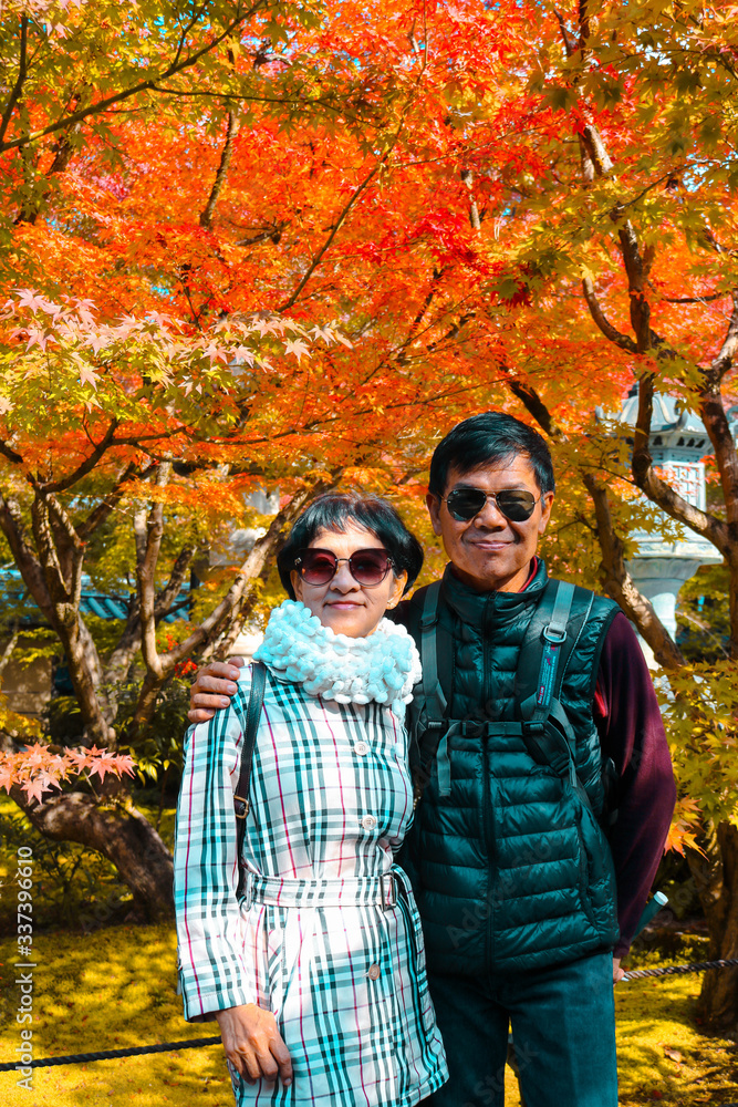 Asian senior couple tourist come to see autumn leaves in garden in spring season at Kyoto, Japan. Autumn leaves is attraction for tourist in Japan. Asian senior couple tourist come to see autumn leaves in garden in spring season at Kyoto, Japan. Autumn leaves is attraction for tourist in Japan.
