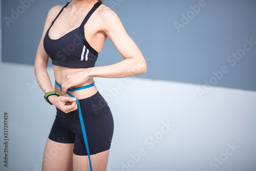 Woman with a tape measure around the waist