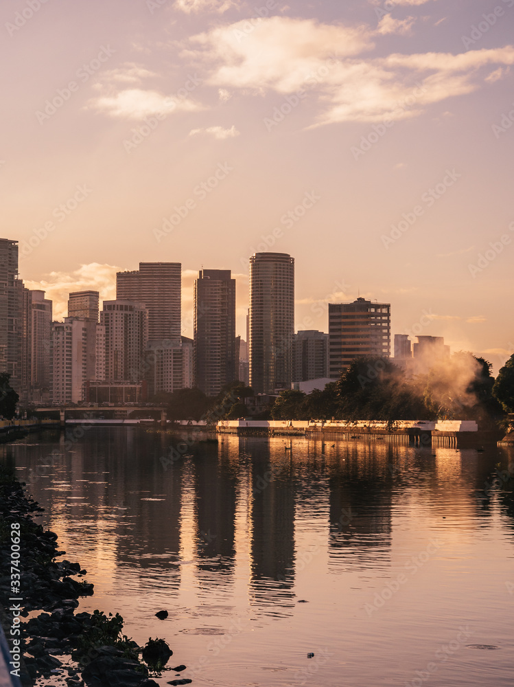 Skyline of Makati City reflecting in the Pasig River in Metro Manila, Philippines while sunrise Skyline of Makati City reflecting in the Pasig River in Metro Manila, Philippines while sunrise