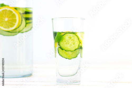 Health care, fitness, healthy eating concept. Fresh cool lemon cucumber drink with water, cocktail, detox drink, lemonade in a glass jug and a glass.