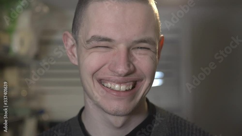 A Man Making A Funny Face With Chinky Eyes And Wide Smile  - Closeup shot photo