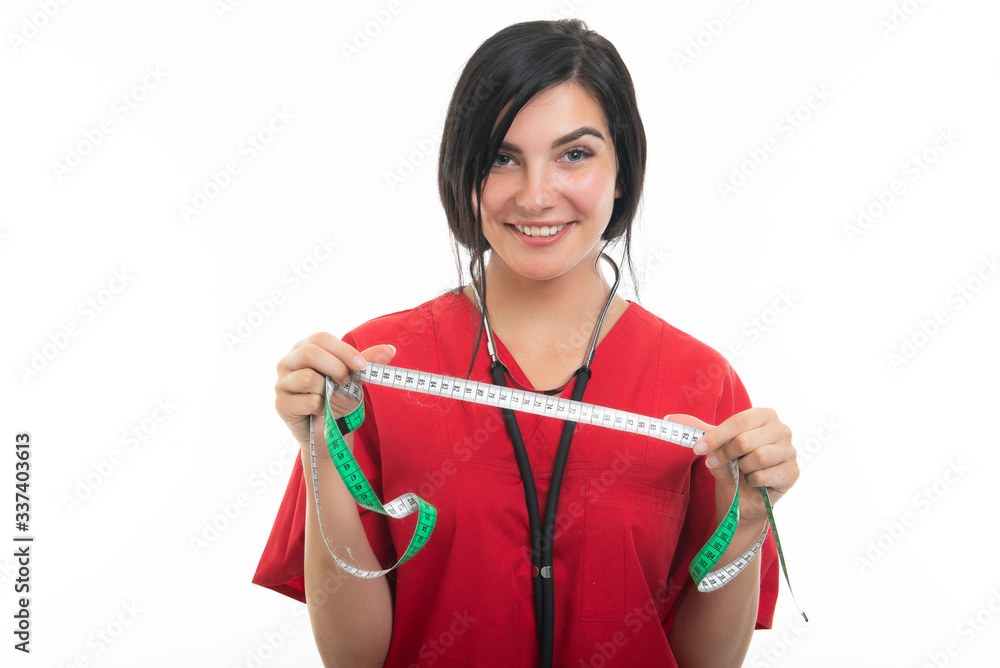 Portrait of young attractive female nurse showing measuring tape Portrait of young attractive female nurse showing measuring tape