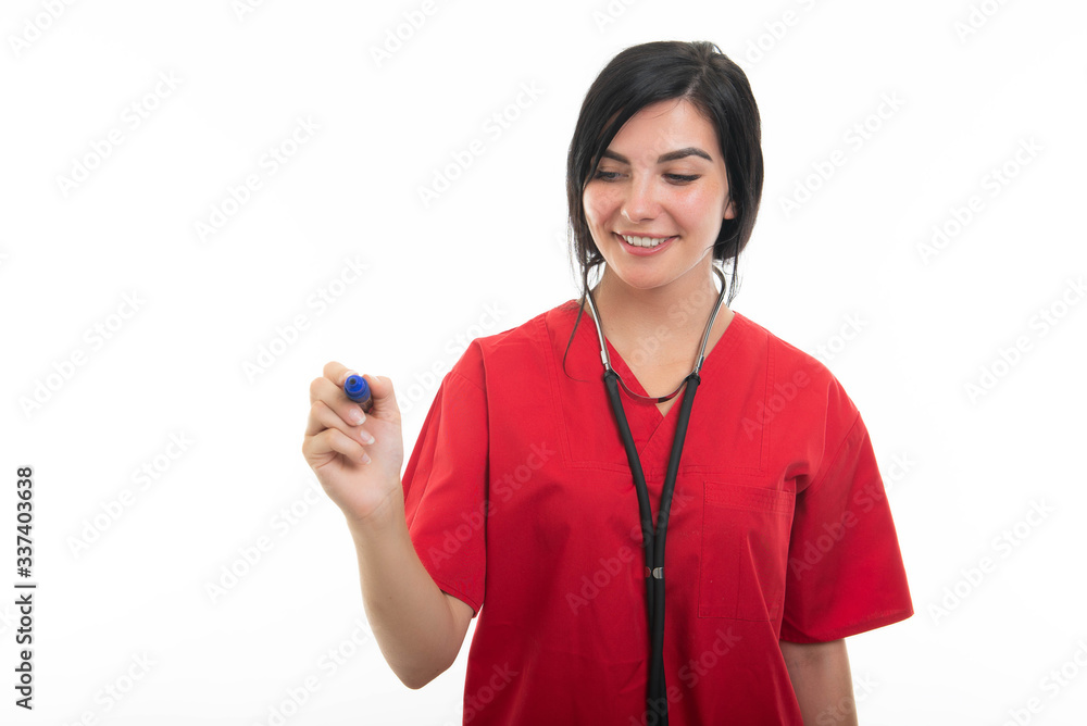 Portrait of young attractive female nurse writing with blue marker Portrait of young attractive female nurse writing with blue marker