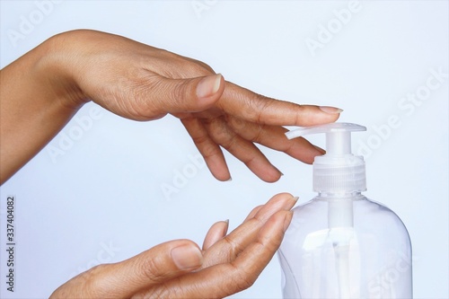 Corona virus or COVID-19 pandemic hygiene concept woman hands pressing soap liquid bottle. photo isolate on white side view copy space 