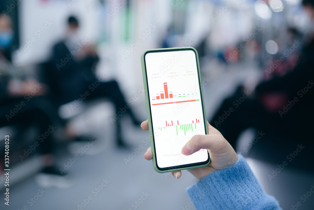 Close up of businesswoman checking financial trading data on smart phone in the subway train. Close up of businesswoman checking financial trading data on smart phone in the subway train.