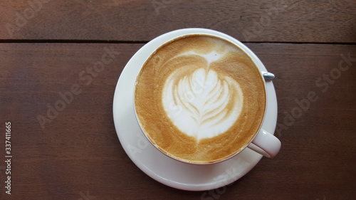 Hot latte with latte art on wood table