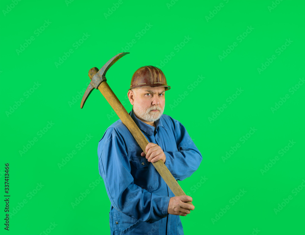 Bearded man in uniform holds pick axe. Builder man holds pickaxe. Craftsman working with pickaxe. Man holding pick-axe. Male miner worker in coveralls with pickaxe. Construction and building works. Bearded man in uniform holds pick axe. Builder man holds pickaxe. Craftsman working with pickaxe. Man holding pick-axe. Male miner worker in coveralls with pickaxe. Construction and building works.