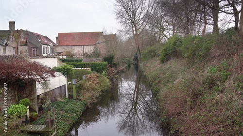 Wallpaper Mural Tilt up shot from the canal to the sky, passing by the trees and houses, on a cloudy day, in Bruges.  Torontodigital.ca