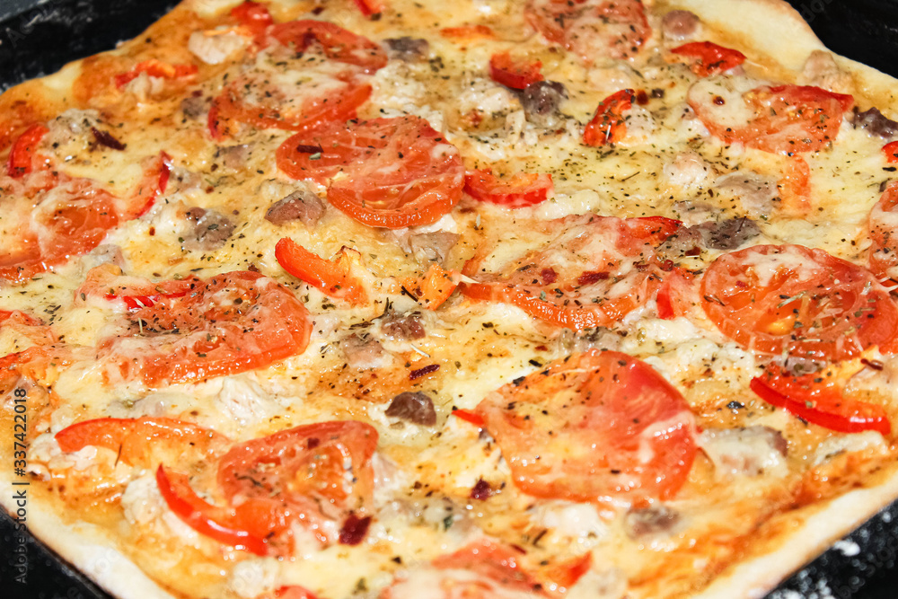 Homemade browned pizza with tomatoes just out of the oven. Homemade browned pizza with tomatoes just out of the oven.