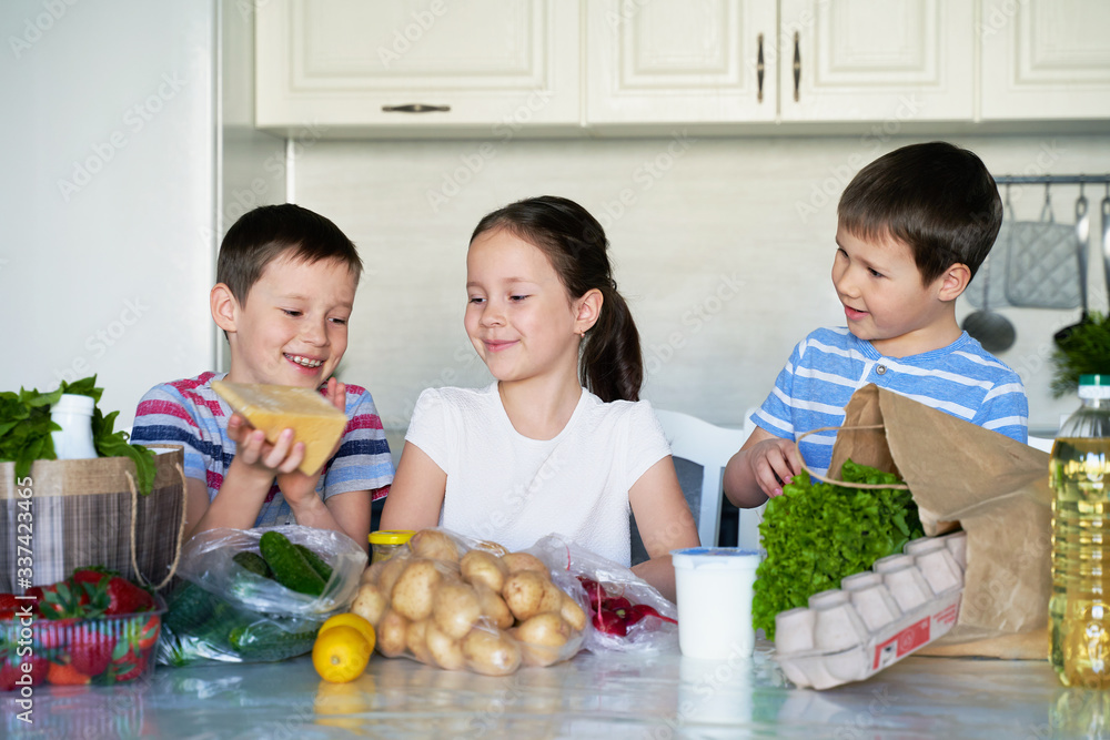children sort out food purchases . lots of food. vegetables. life in quarantine. children sort out food purchases . lots of food. vegetables. life in quarantine.