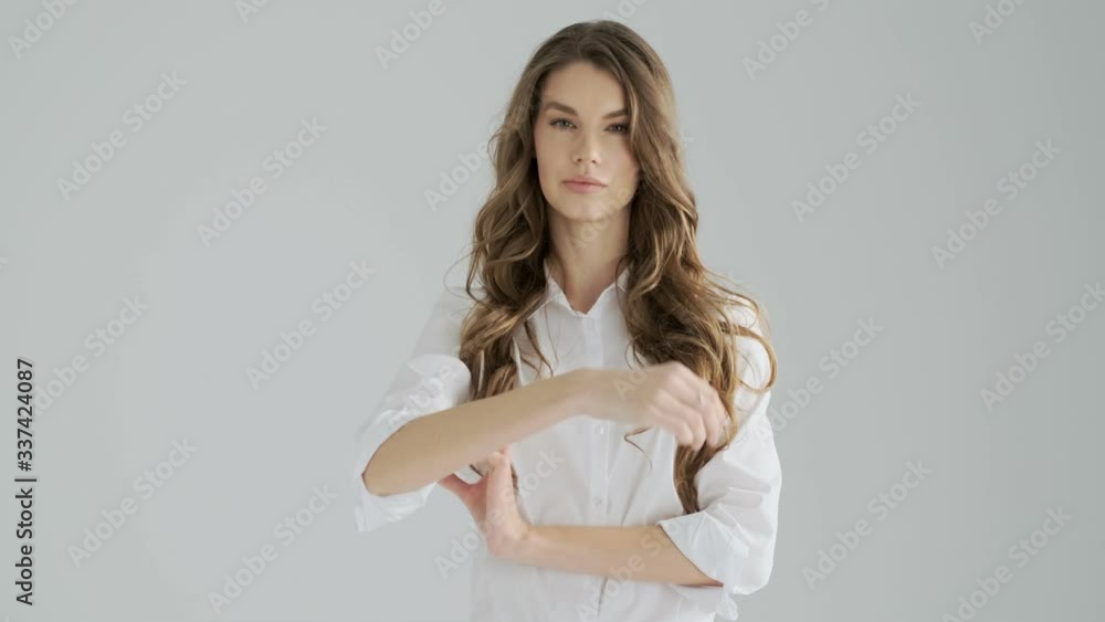 A displeased serious young woman is shaking her finger negatively isolated over a gray background in studio A displeased serious young woman is shaking her finger negatively isolated over a gray background in studio