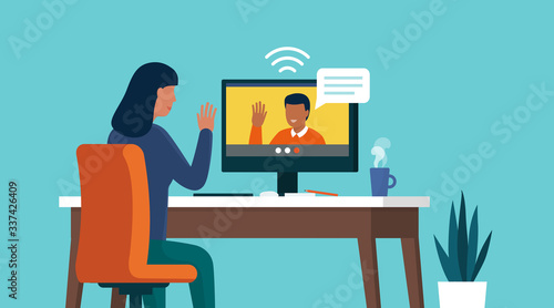 Woman video calling her friend online using her computer