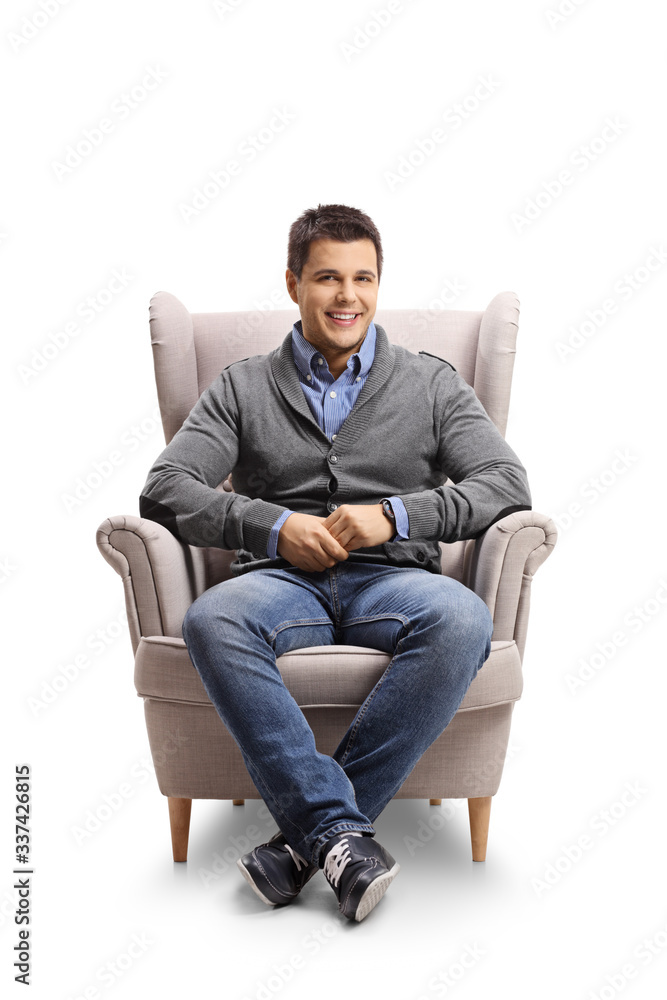 Smiling young man sitting in an armchair