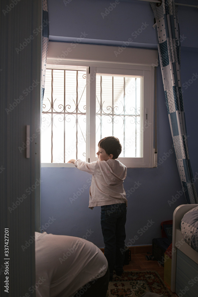 boy looks out the bedroom window while his mother orders the clothes
boy looks out the bedroom window while his mother orders the clothes