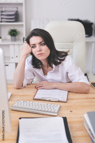 Young tired or annoyed businesswoman waiting for online page uploading