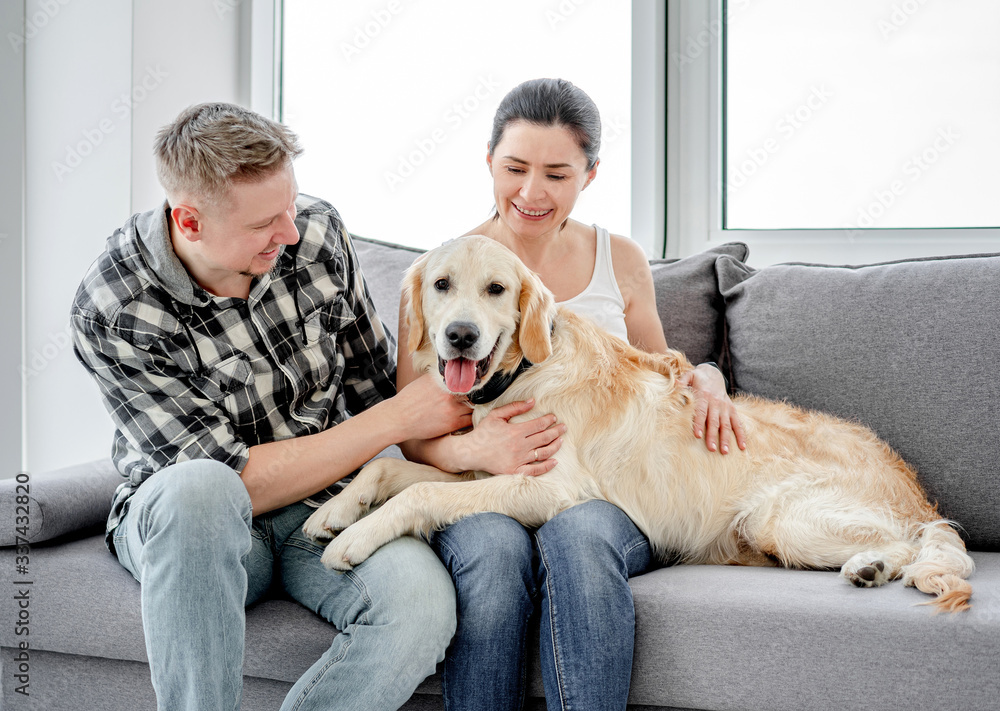 Woman and man cuddling cute dog Woman and man cuddling cute dog