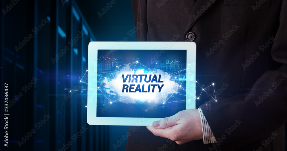 Young business person working on tablet and shows the inscription: VIRTUAL REALITY Young business person working on tablet and shows the inscription: VIRTUAL REALITY