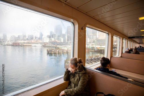 A young women looking out the window of a ferry boat on the Seattle waterfront.