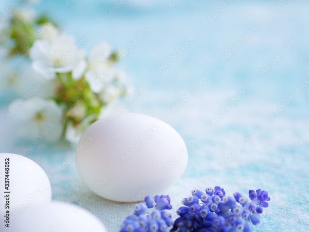 Easter uncolored white and brown eggs on a light blue background with flowers decoration