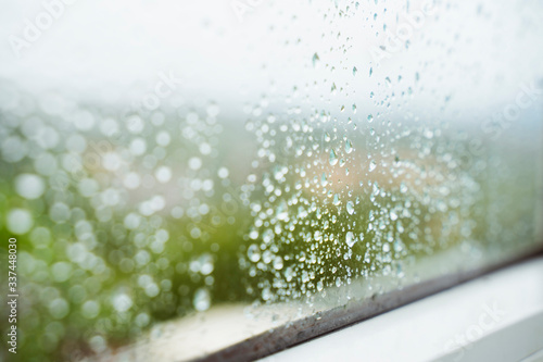 Drops of rain horizontal background. Winter seasonal time. Humidity and rainy weather inside home. Water condensation on window. Detail of wet drops of rain stick to a clean window at home.