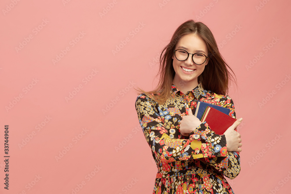 A young pretty girl student, with books from the library, smiling sweetly. Distance learning of foreign languages. A young pretty girl student, with books from the library, smiling sweetly. Distance learning of foreign languages.