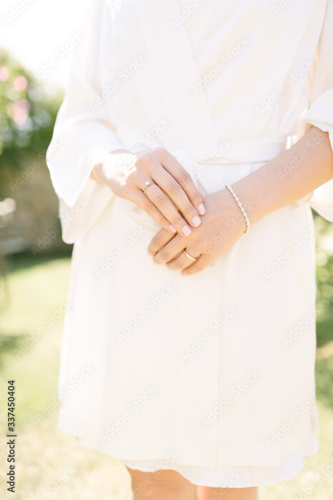 Wedding ring and bracelet. The bride poses with a dressing gown. Wedding ring and bracelet. The bride poses with a dressing gown.