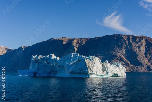Greenland landscape with beautiful coloured rocks and iceberg.