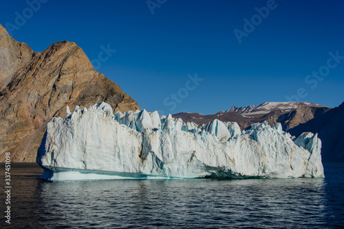 Greenland landscape with beautiful coloured rocks and iceberg.