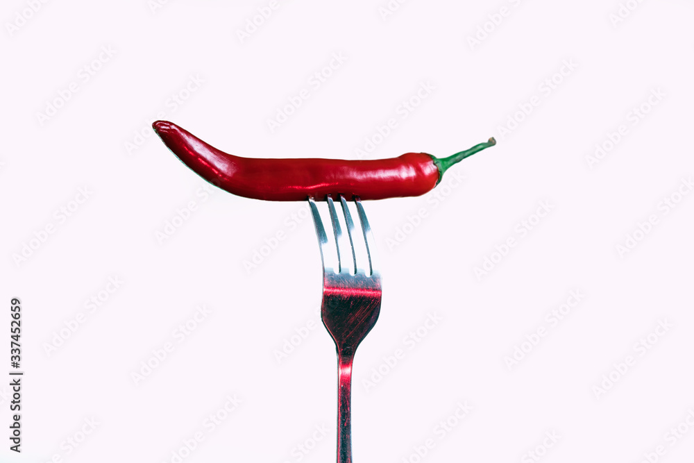Red chili pepper on a fork. Sharp fork and about hot pepper. Red chili pepper on a fork. Sharp fork and about hot pepper.