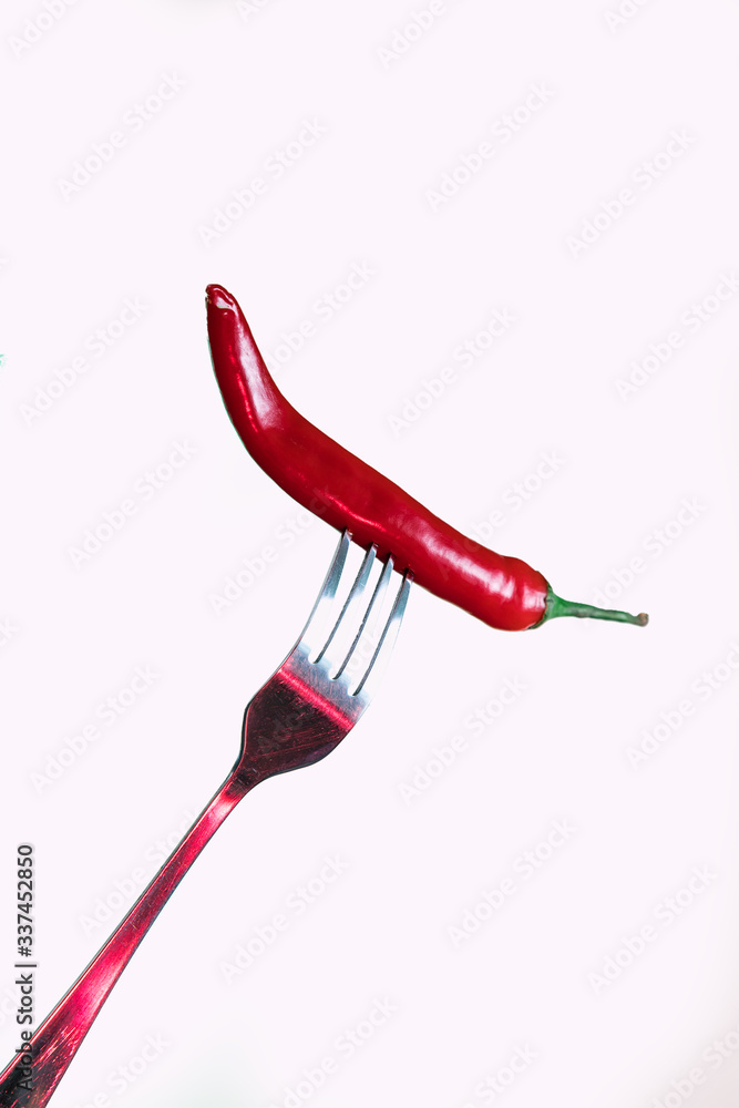 Red chili pepper on a fork. Sharp fork and about hot pepper. Red chili pepper on a fork. Sharp fork and about hot pepper.