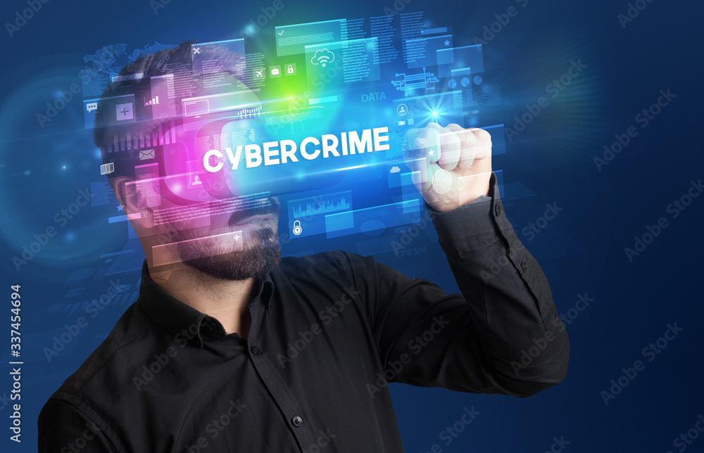 Businessman looking through Virtual Reality glasses with CYBERCRIME inscription, innovative security concept