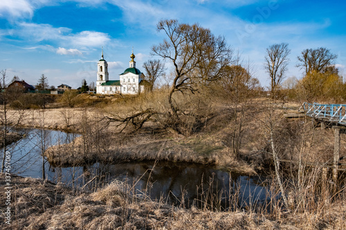 Fototapeta Naklejka Na Ścianę i Meble -  Spring rural landscape with a white-stone church in the village of Sidorovskoye, Ivanovo Region.