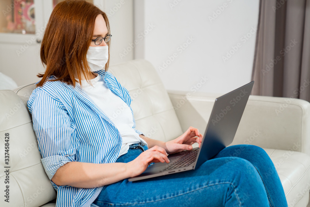 female in medical mask works with computer online. female in medical mask works with computer online.