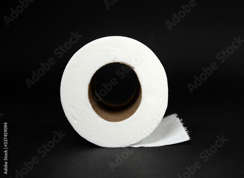 side view of roll of white toilet paper isolated on black