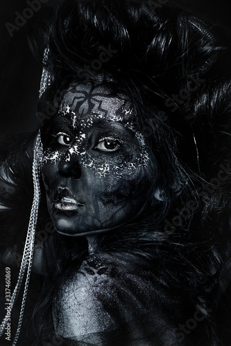 close up portrait of terribly beautiful girl with Halloween skull makeup. Black face painting. lush hair