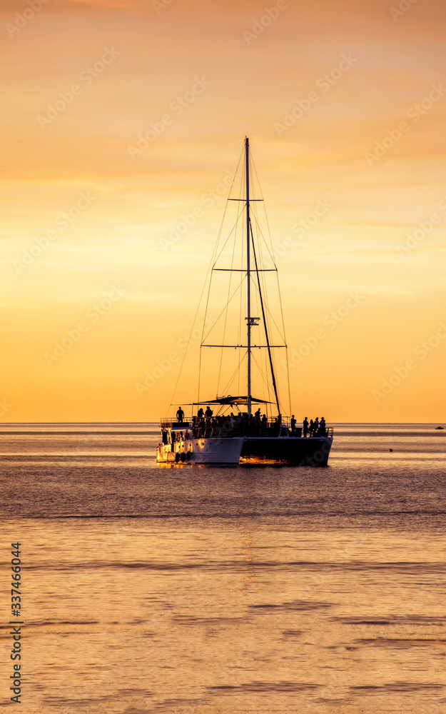 Western Australia – Silhouette of people celebrating on a catamaran at the sunset evening light at the sea