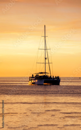 Western Australia     Silhouette of people celebrating on a catamaran at the sunset evening light at the sea