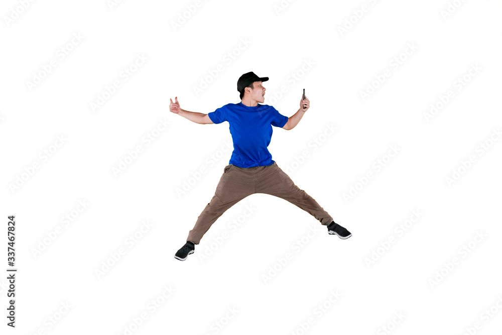 Young man leaping in the air with his smartphone