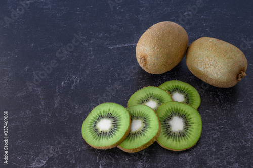 Kiwi Fruit on Black Slate surface and sliced