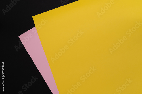 Yellow and pink paper. Paper texture background. Color. Copy space. Dark mode style. Top view. Minimal concept