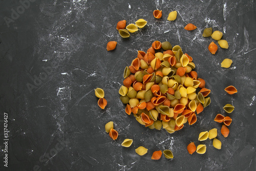 Pasta Conchiglie Rigate, mix of colorful uncooked shells In the form of a circle. Textured Italian food background concept. Top view flat lay close up photo