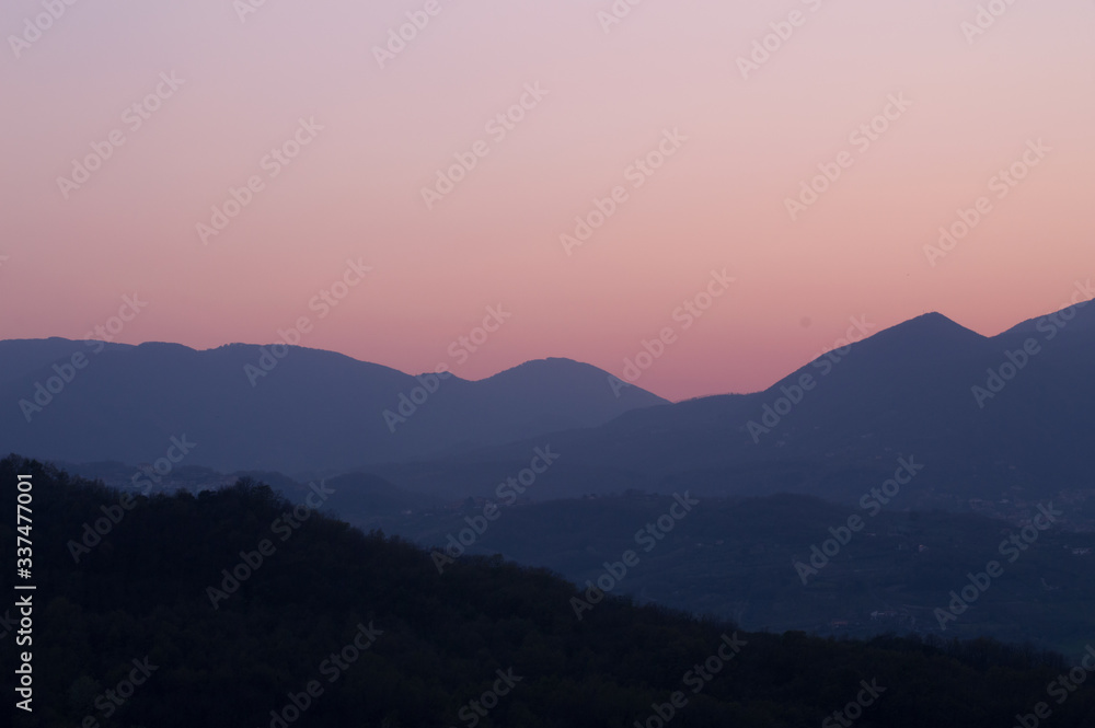 A pink sunset between the mountains.