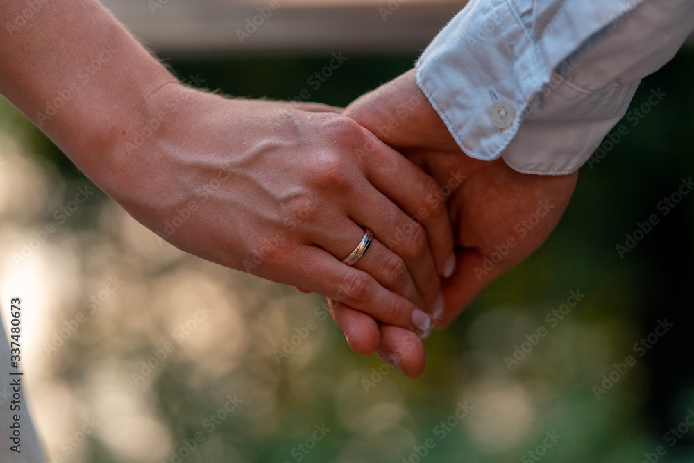 Close up of Bride and Groom Holding Hands With Wedding Rings On It. Giving of Wedding Rings And Vows Outdoors . Wedding In Park.