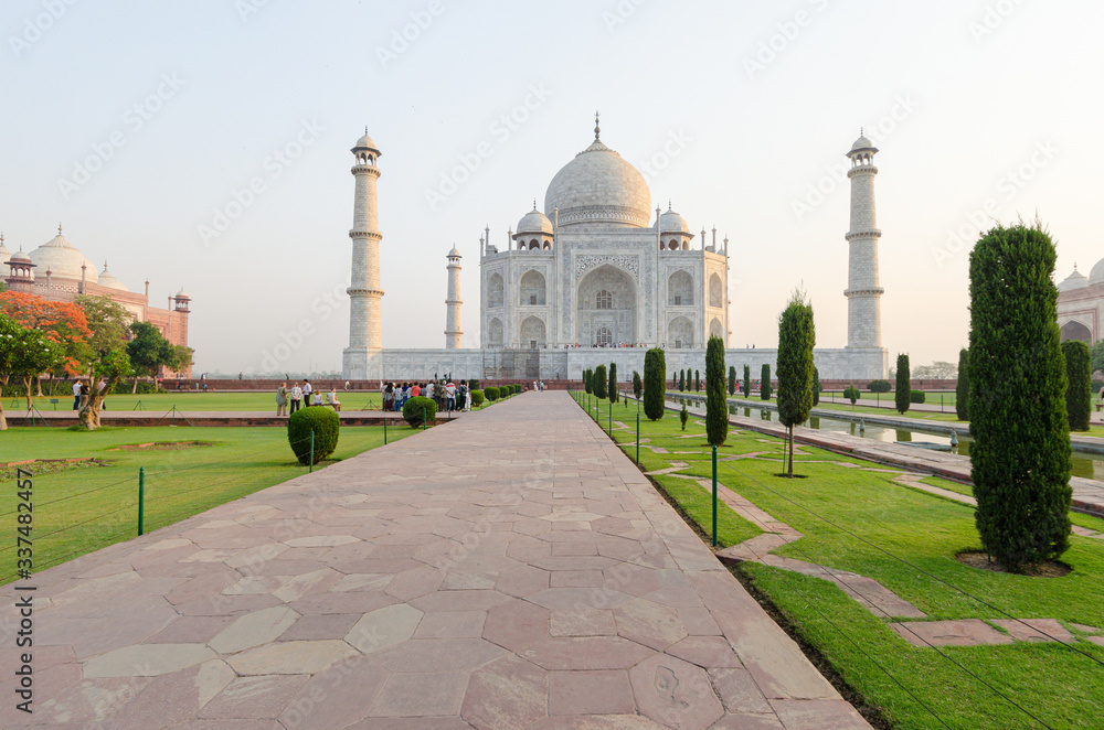 Tourists walk the gardens around the iconic mausoleum in the Taj Mahal complex, Agra, India
